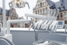 Een fotorealistisch beeld van een lege, moderne tandartsstoel met strakke, zilverkleurige en witte tandheelkundige instrumenten, helder verlicht in een schone kliniek. Op de zeer onscherpe achtergrond is een zacht verlicht stedelijk landschap met klassieke Belgische architectuur te zien, vervaagd tot een abstract patroon.