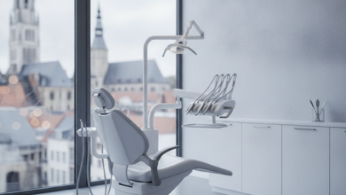 A pristine, modern dental clinic interior featuring a sleek dental chair in the foreground. Through a large window, a blurred but recognizable cityscape of Ghent, Belgium, is visible in the background. The lighting is soft and professional, emphasizing a clean and reassuring environment.